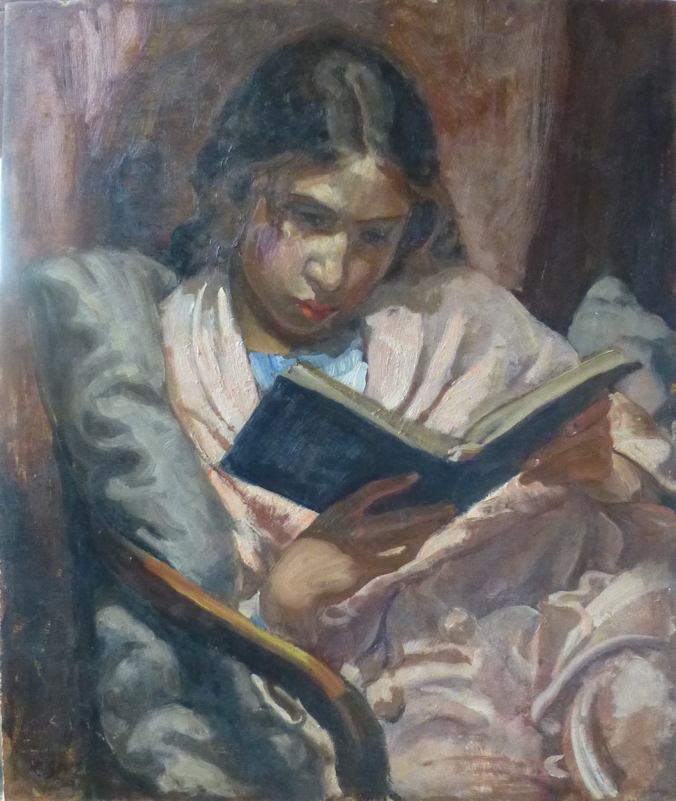 Girl seated reading wrapped in pink blanket
